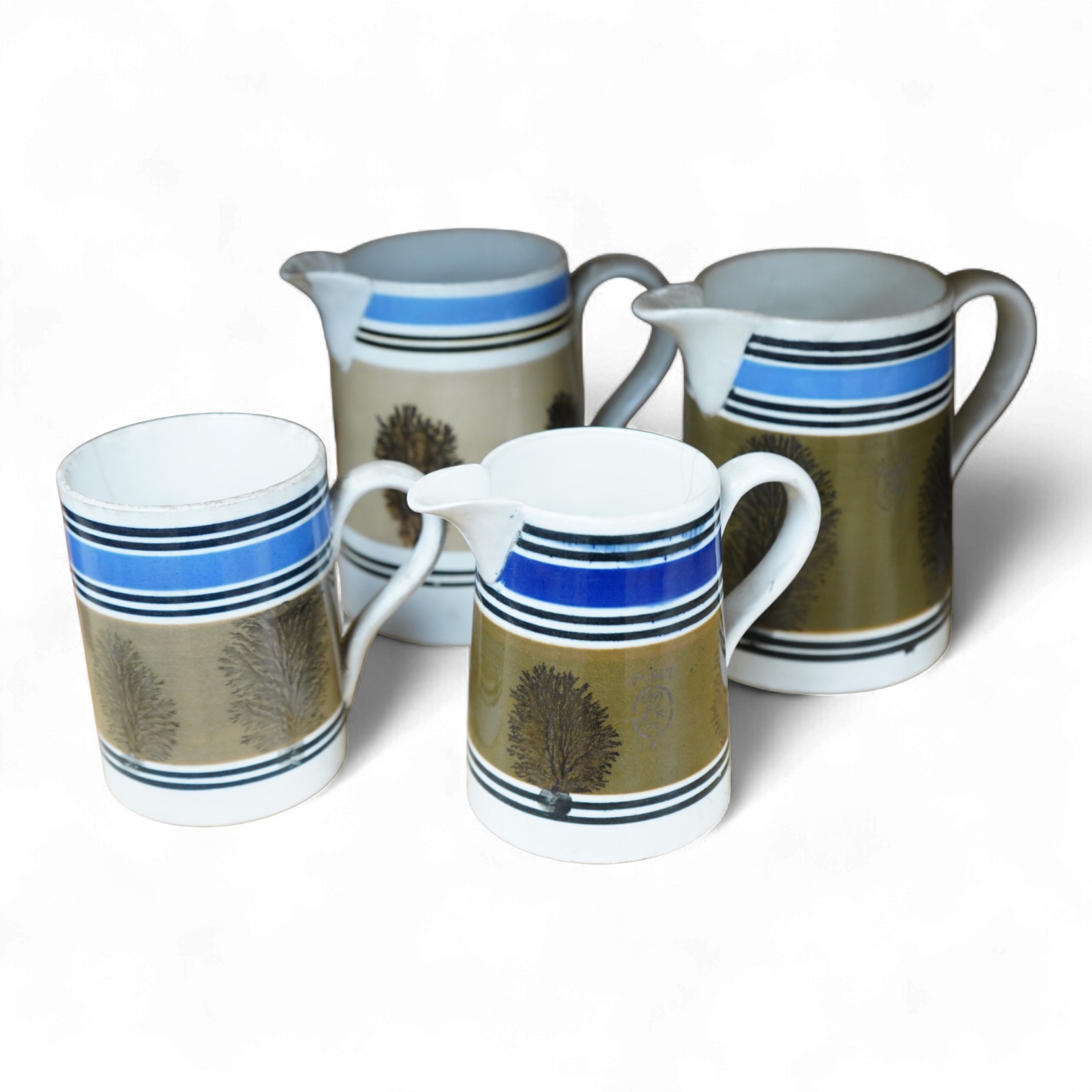 Three early 19th century Mocha ware jugs and a mug, largest 16cm high